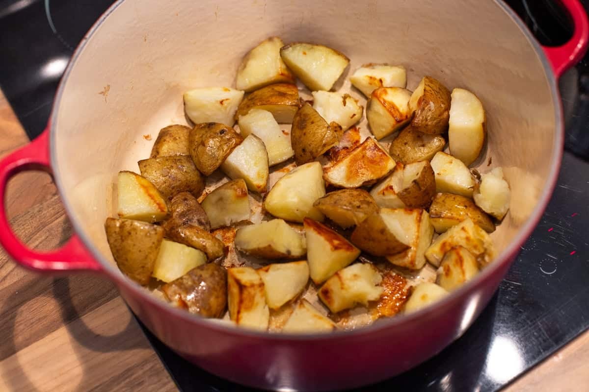 Roasted potatoes in a large pot.