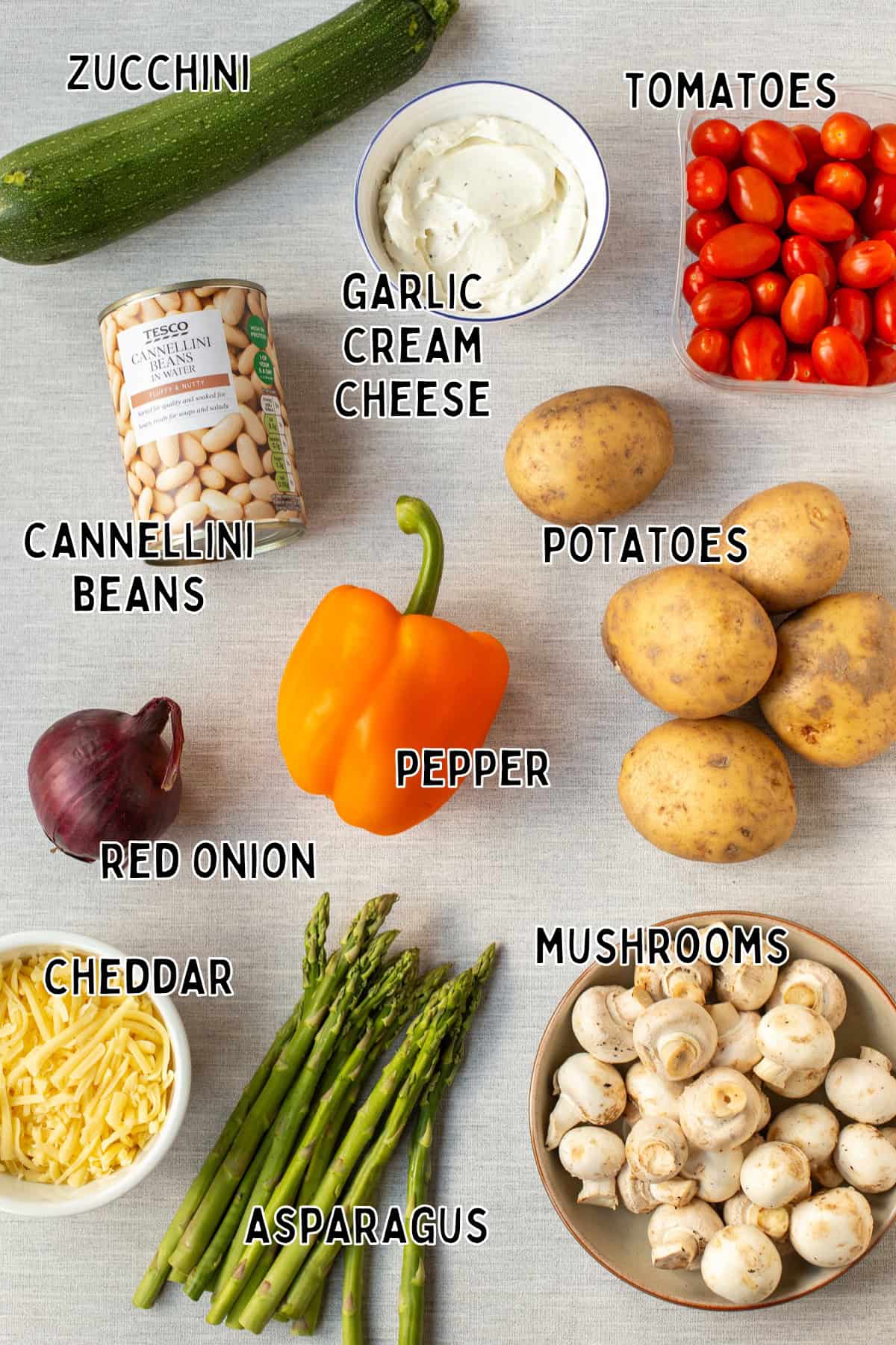 Ingredients for cheesy vegetable potato bake laid out with text overlay.