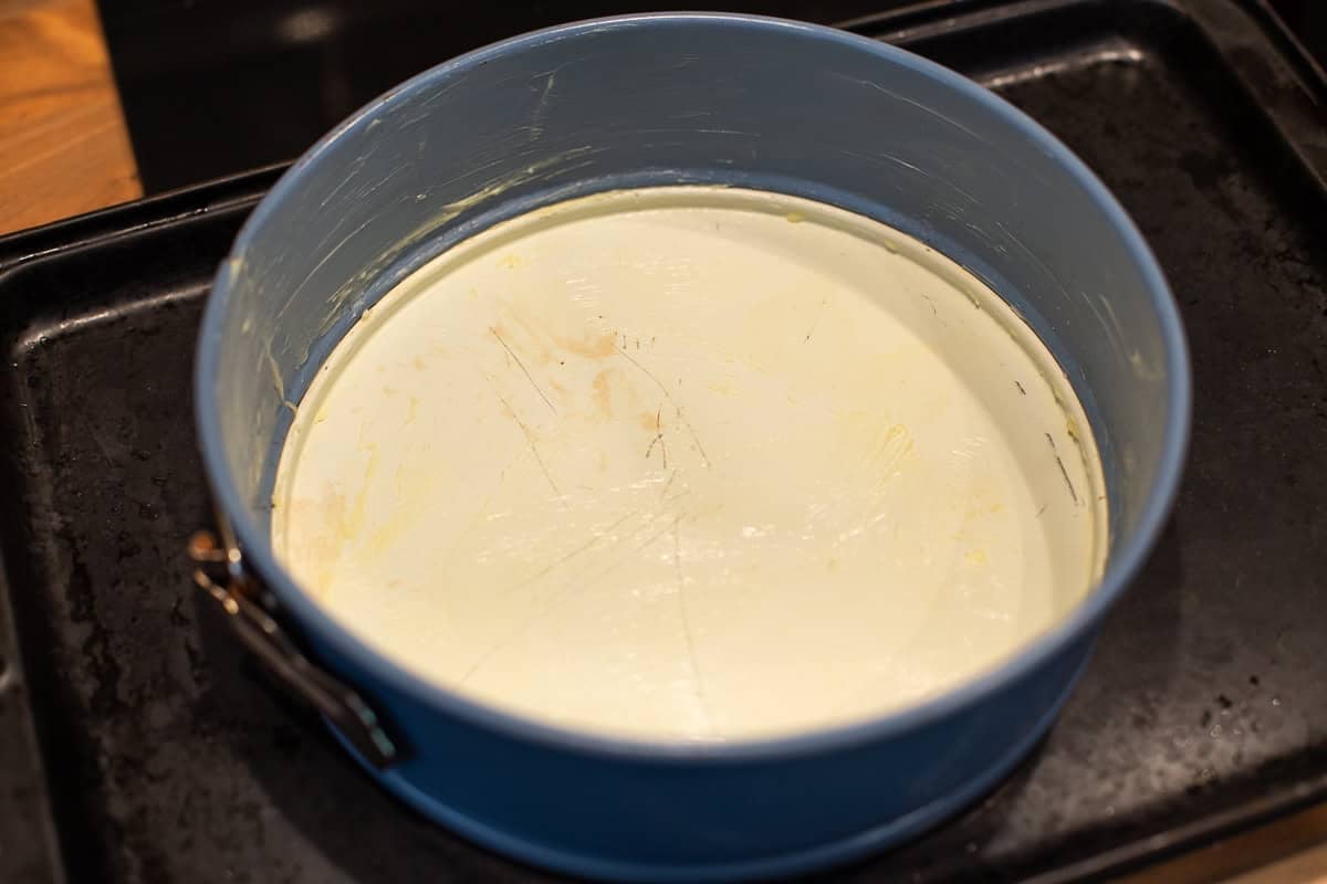 A springform cake tin greased with butter.