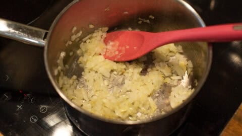 Finely chopped sautéed onion in a saucepan.