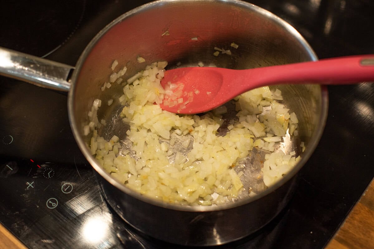 Finely chopped sautéed onion in a saucepan.