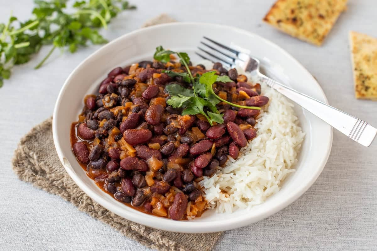 Easy kidney bean curry served in a bowl with rice and cilantro.