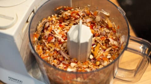 Chopped vegetables and walnuts in a food processor.
