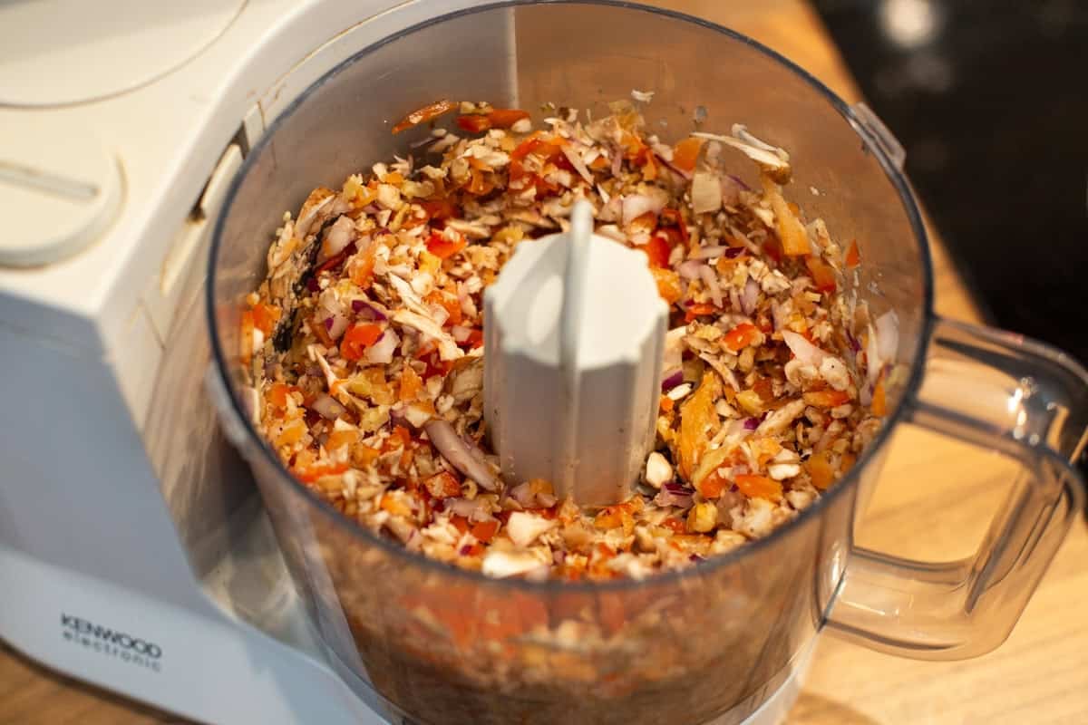 Chopped vegetables and walnuts in a food processor.