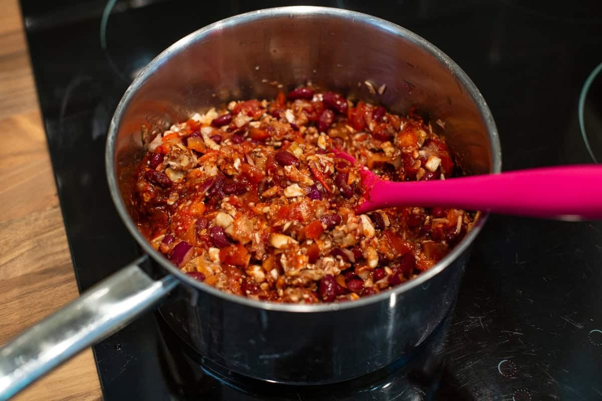 Uncooked vegetarian bean chilli in a saucepan.