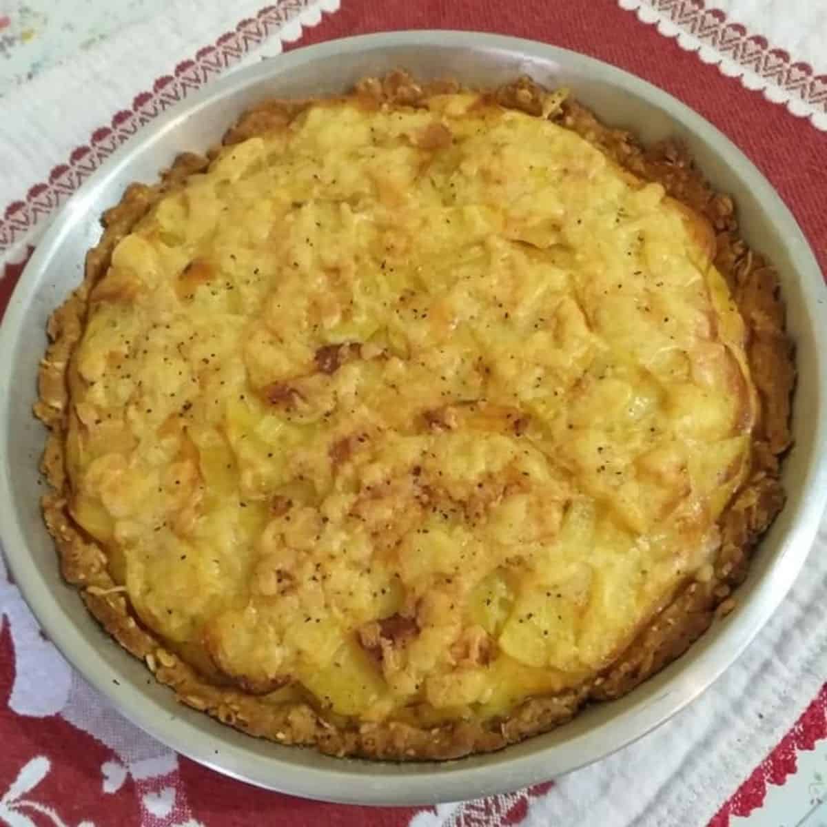 Cheesy lentil and potato pie in a tin.