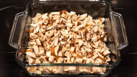 Chopped mushrooms and onion in a baking dish.