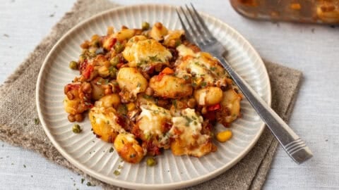 A plate of vegetarian shepherd's pie gnocchi with a fork.