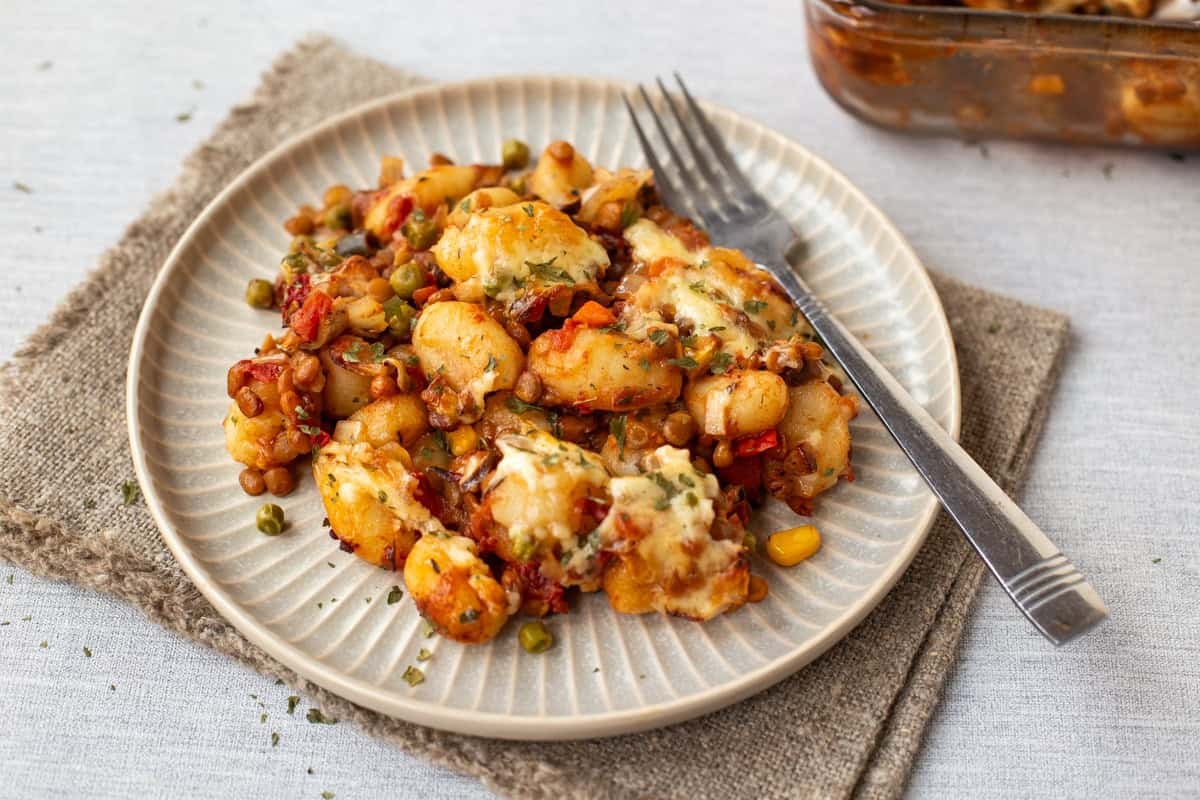 A plate of vegetarian shepherd's pie gnocchi with a fork.