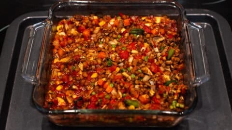 Cooked tomatoey lentil and vegetable mixture in a baking dish.