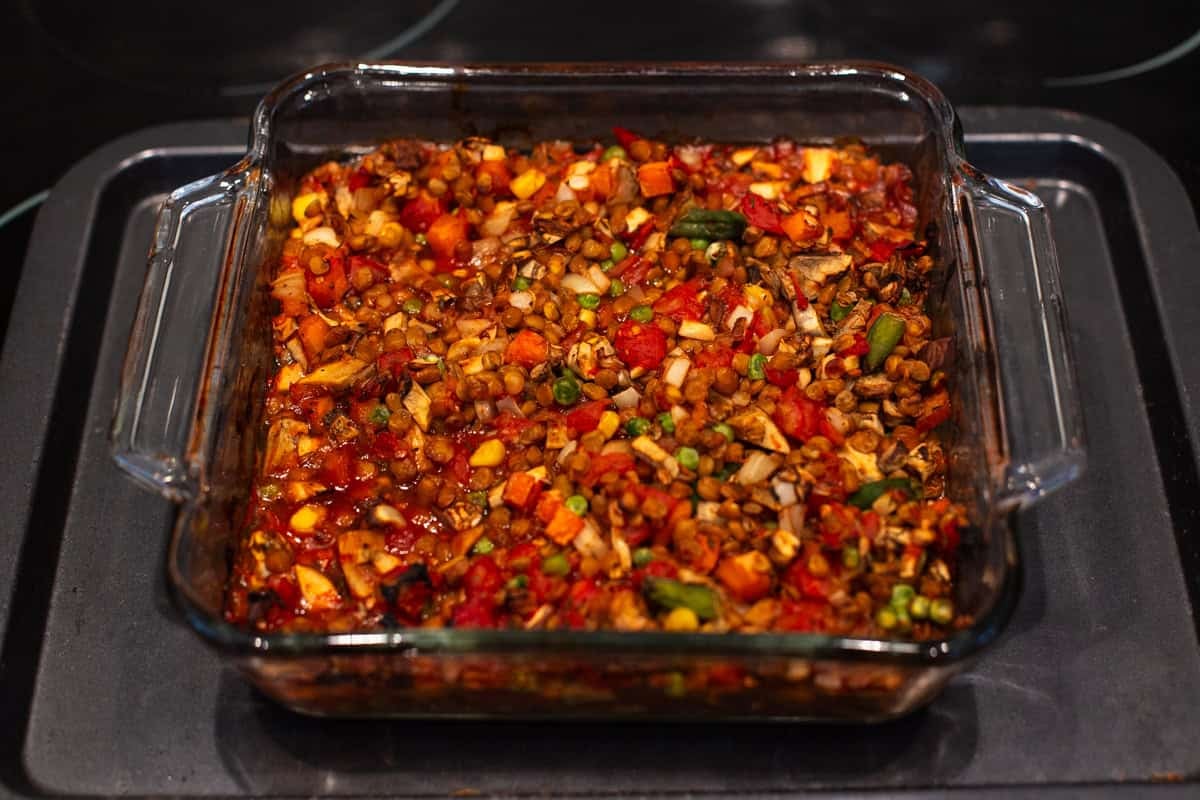 Cooked tomatoey lentil and vegetable mixture in a baking dish.