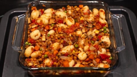 Vegetarian shepherd's pie mixture with gnocchi in a baking dish.