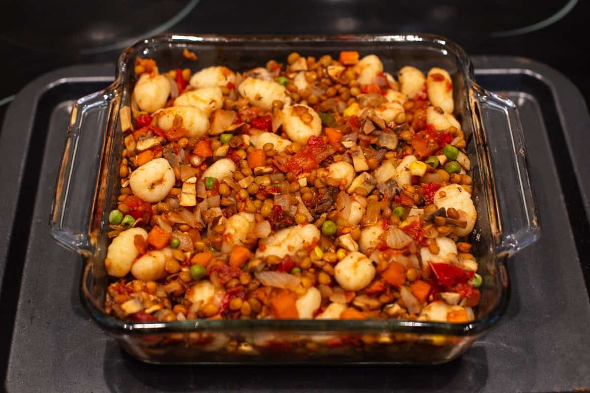 Vegetarian shepherd's pie mixture with gnocchi in a baking dish.