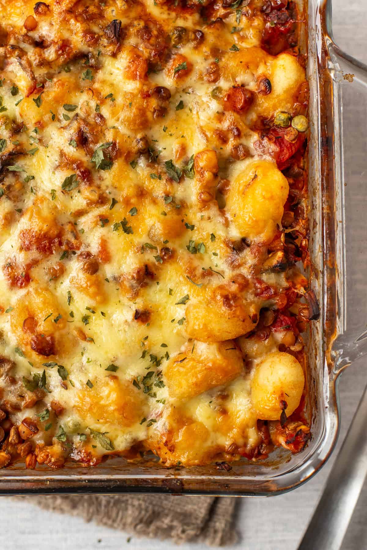 A pan of vegetarian shepherd's pie gnocchi with a cheesy topping.