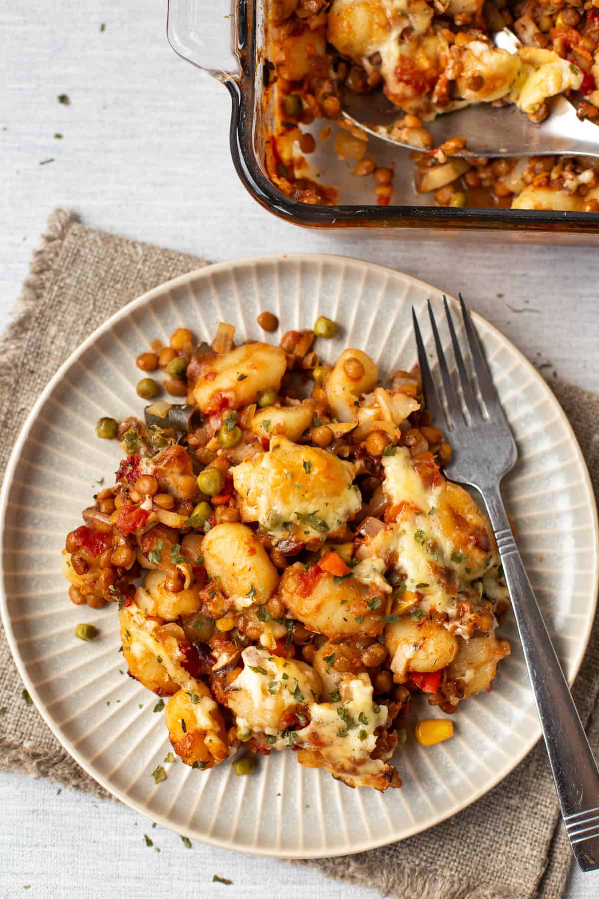 Overhead shot of cheesy vegetarian shepherd's pie gnocchi on a plate.