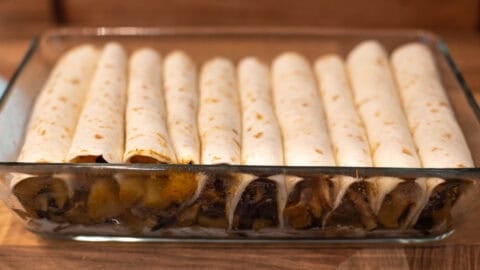 Rolled tortillas in a baking dish.
