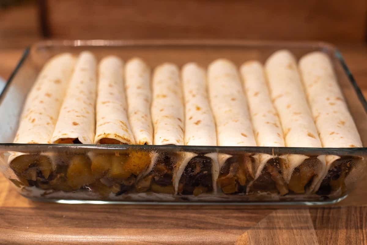 Rolled tortillas in a baking dish.