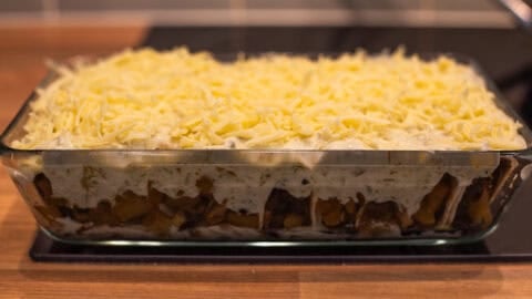 An uncooked pan of cheesy potato enchiladas.