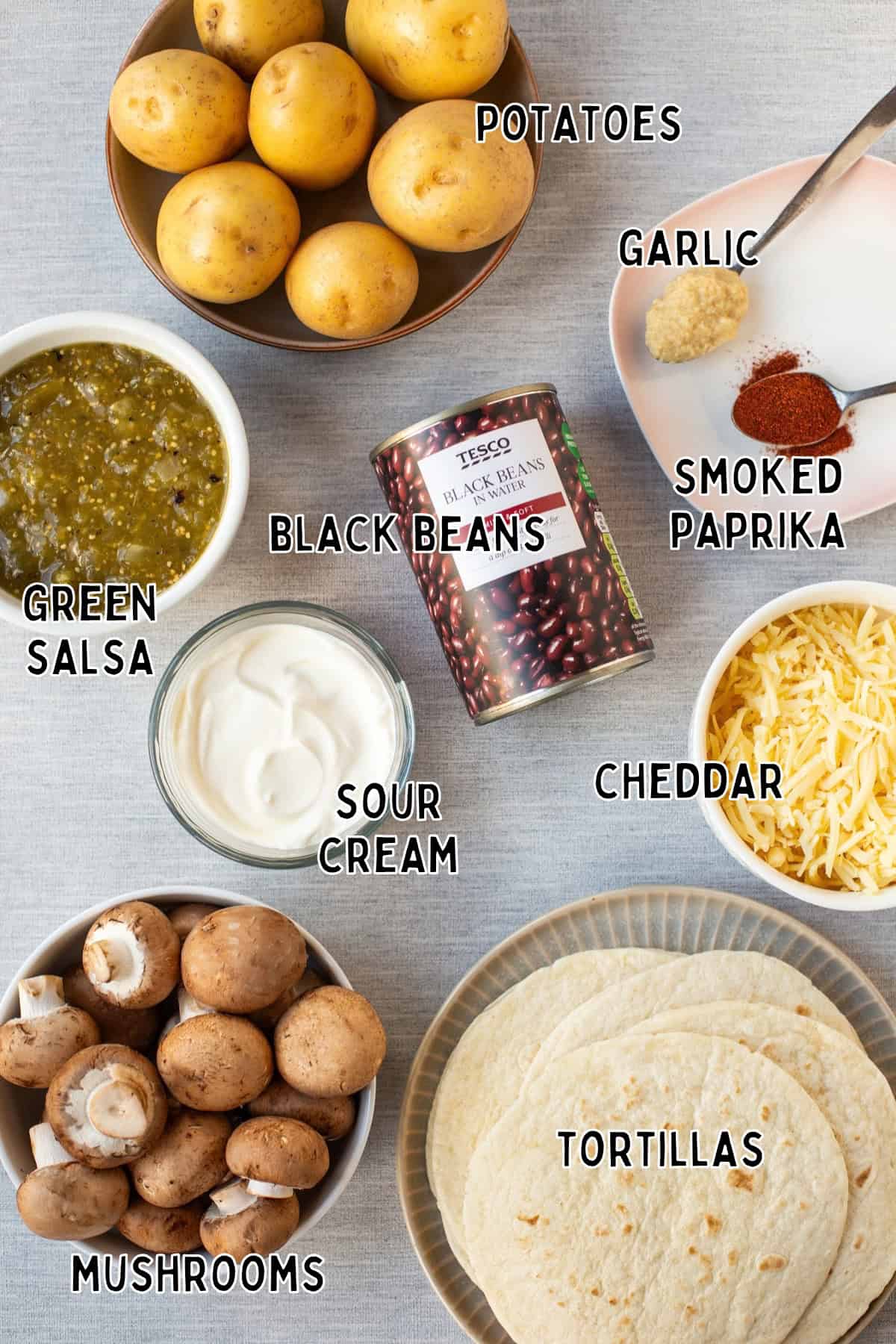 Ingredients for cheesy potato enchiladas laid out with text overlay.