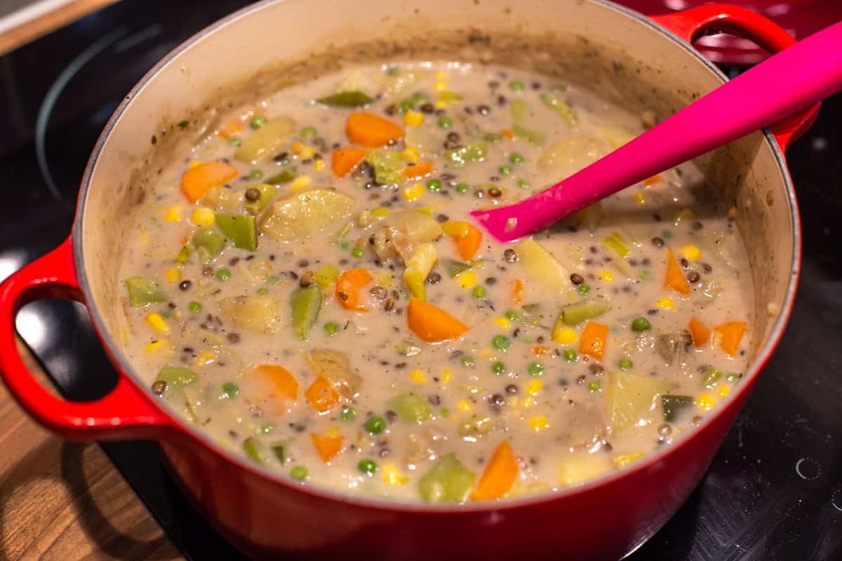 Creamy vegetable stew cooking in a large pot.