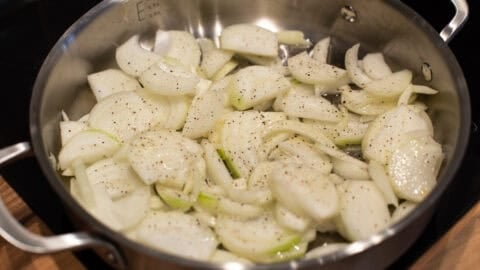 Raw onions in a metal pan.