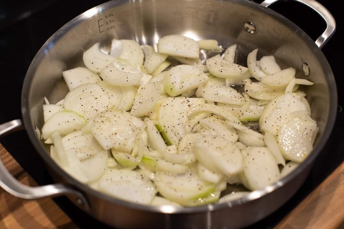 Raw onions in a metal pan.