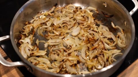 Cooked onions in a metal pan.