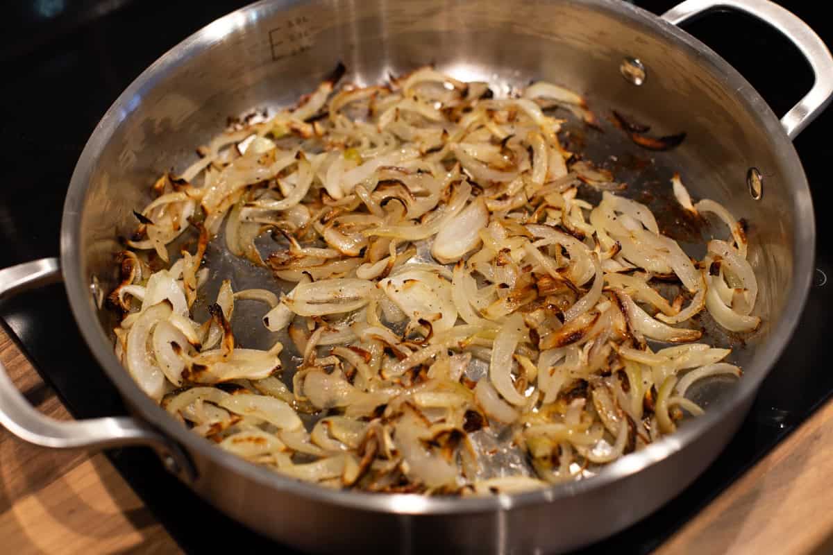 Cooked onions in a metal pan.