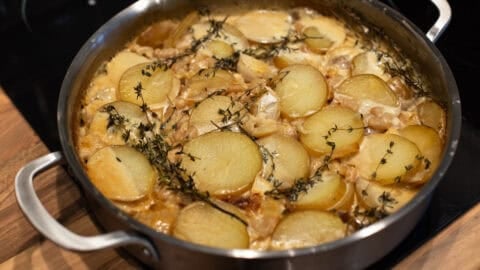 Cooked creamy potato bake in a metal pan.