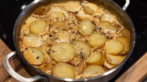 Cooked potatoes, beans and cream in a metal pan.