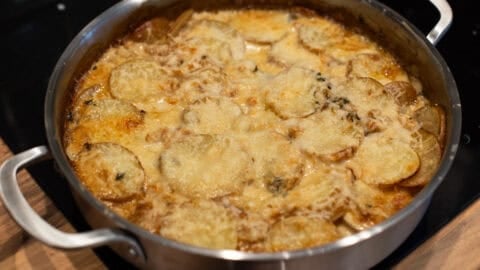 Cheesy French onion potato bake in a pan.
