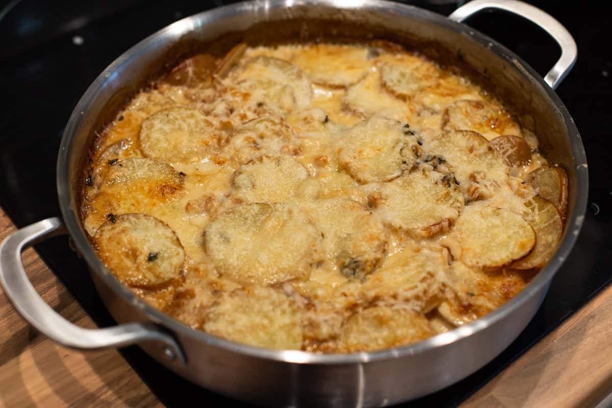 Cheesy French onion potato bake in a pan.